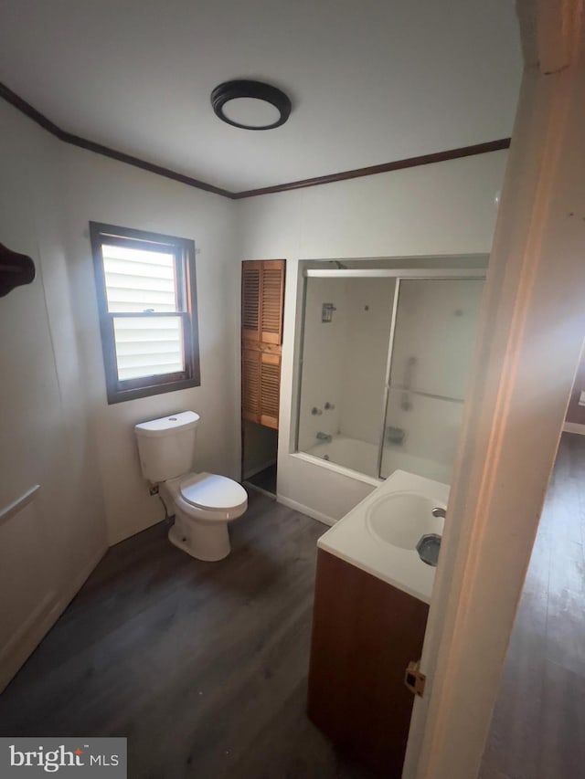 full bath with toilet, ornamental molding, vanity, shower / tub combination, and wood finished floors