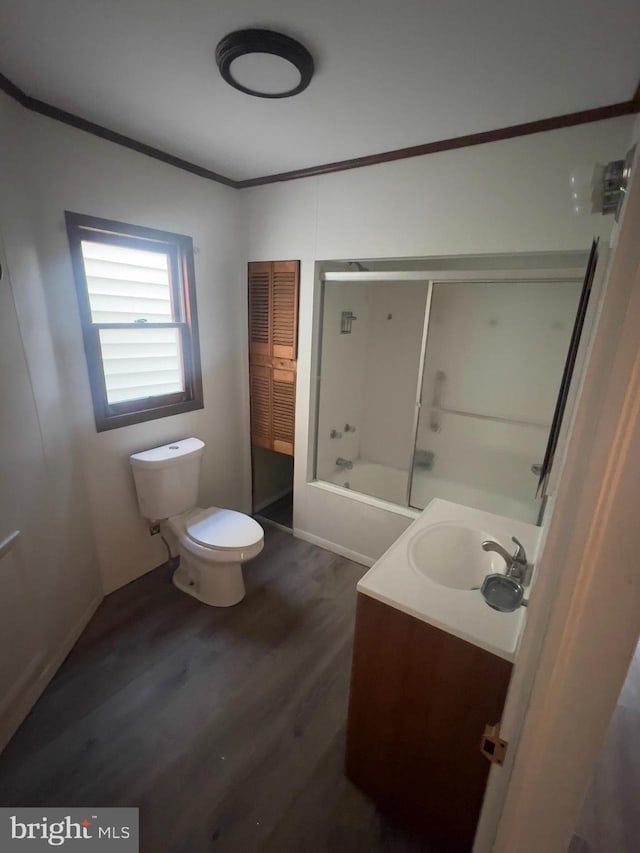 full bath with crown molding, toilet, combined bath / shower with glass door, vanity, and wood finished floors