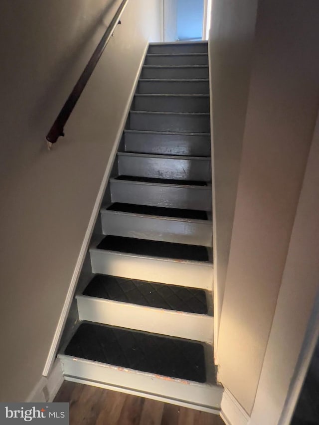 stairs featuring wood finished floors