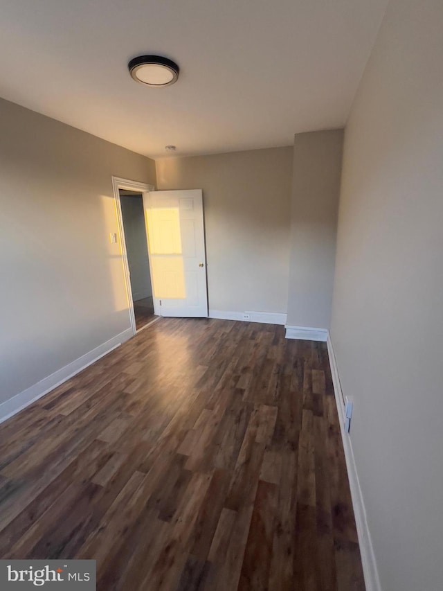 interior space with baseboards and dark wood-style flooring