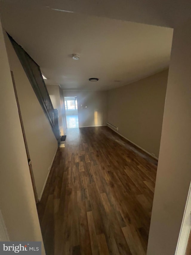 hallway with baseboards and dark wood-type flooring