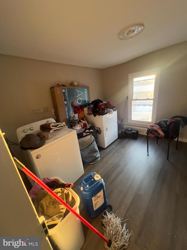 clothes washing area with dark wood-style floors, laundry area, and washing machine and clothes dryer