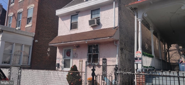 view of front of house featuring a fenced front yard, stucco siding, and cooling unit