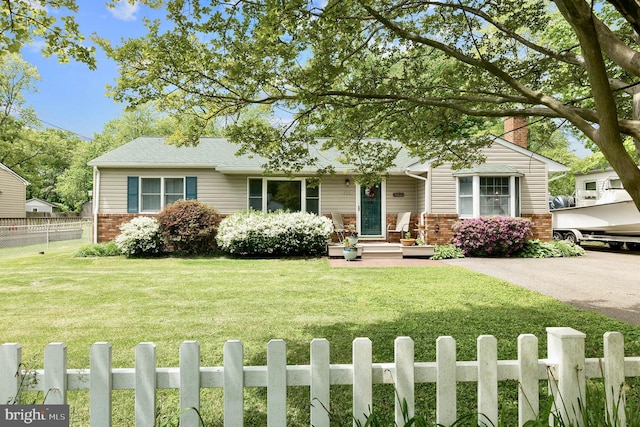 view of front of property with a chimney, fence, a front lawn, and brick siding