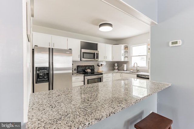 kitchen featuring stainless steel appliances, a sink, white cabinetry, backsplash, and open shelves