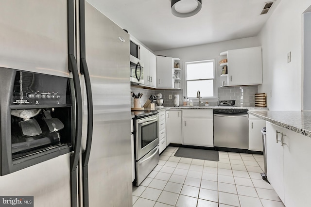 kitchen featuring light tile patterned flooring, stainless steel appliances, visible vents, backsplash, and open shelves