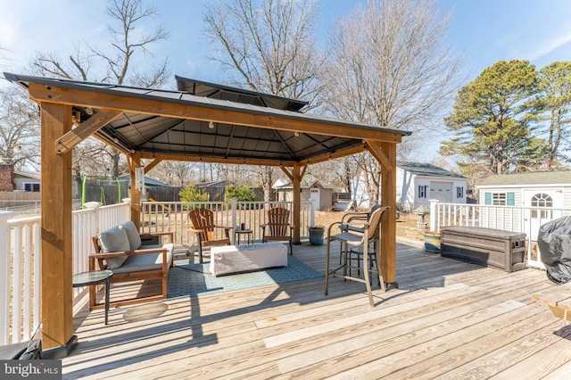 deck with an outbuilding, fence, an outdoor living space, and a gazebo