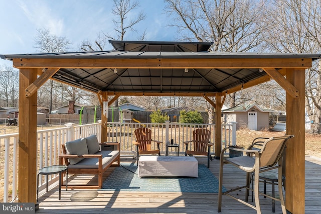 wooden deck with an outbuilding, outdoor lounge area, a gazebo, and a storage shed