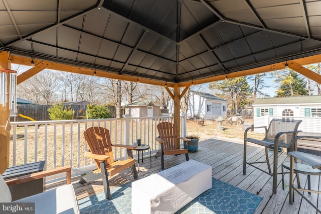 deck featuring a storage shed, a residential view, fence, a gazebo, and an outdoor structure