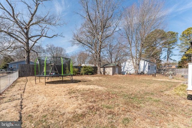 view of yard with a fenced backyard, a trampoline, and an outdoor structure