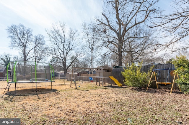 view of yard with a fenced backyard, a trampoline, and a playground