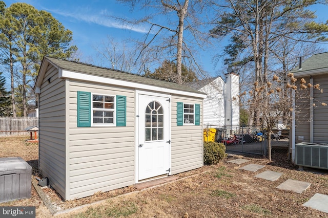 view of outbuilding with central AC, fence, and an outdoor structure