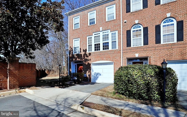 view of front of property with driveway, a garage, and brick siding