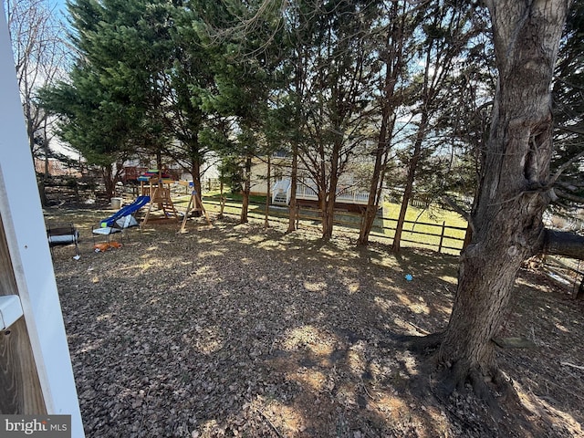 view of yard featuring a playground and fence