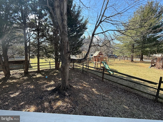 view of yard with fence and a playground