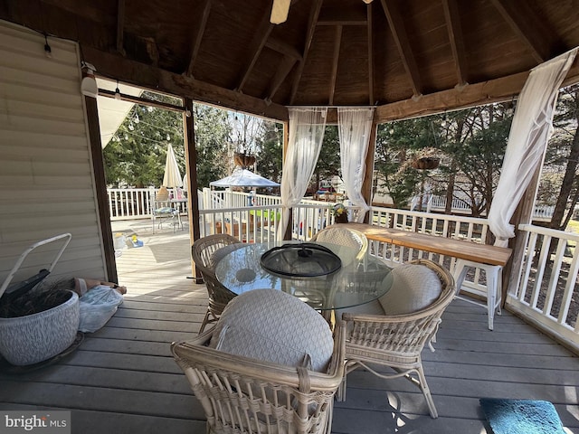 deck featuring outdoor dining area and a gazebo