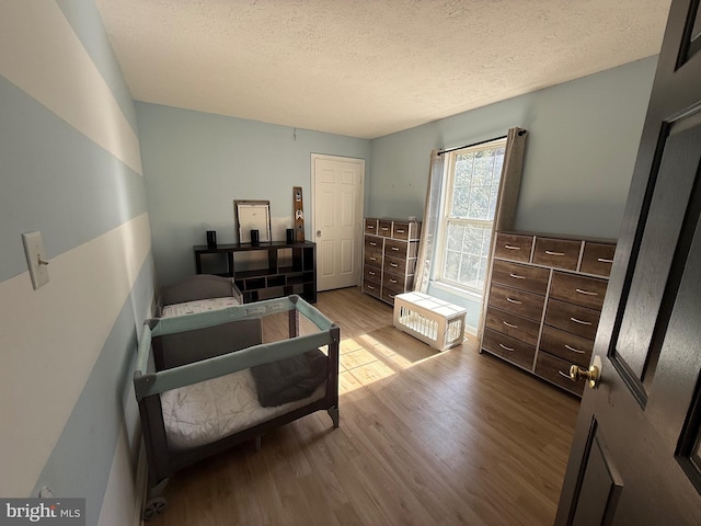 bedroom featuring a textured ceiling and wood finished floors