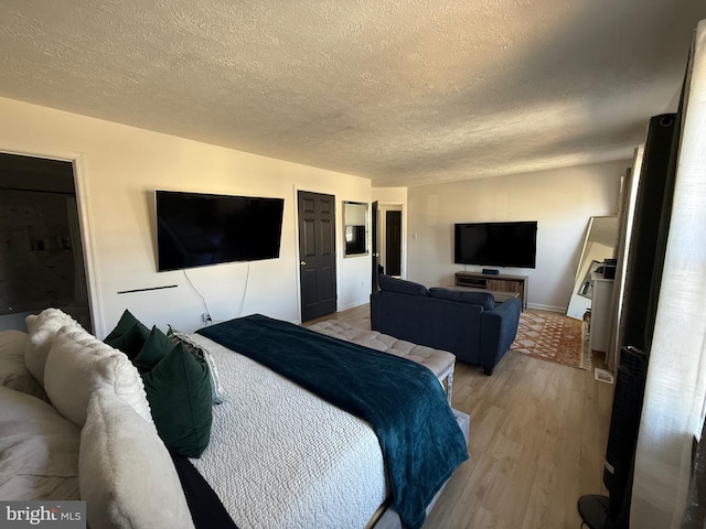 bedroom with light wood-style flooring and a textured ceiling