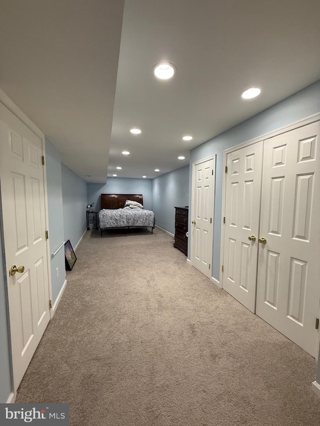 unfurnished bedroom with baseboards, carpet floors, multiple closets, and recessed lighting