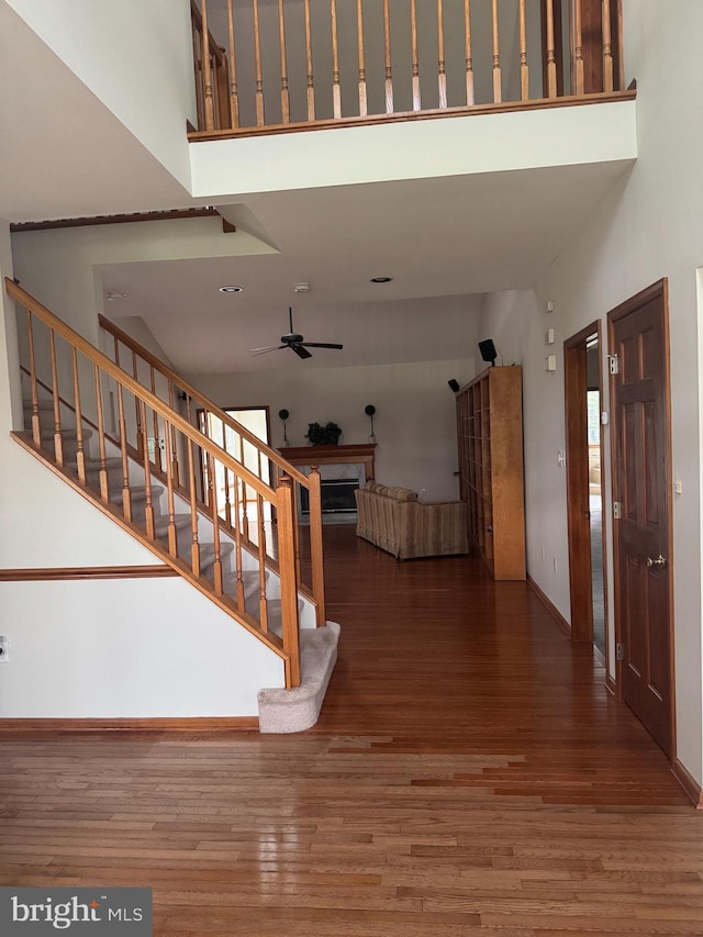 200 Stewards Ct, Bear, DE 19701 - staircase with a high ceiling, ceiling fan, wood finished floors, a fireplace, and baseboards