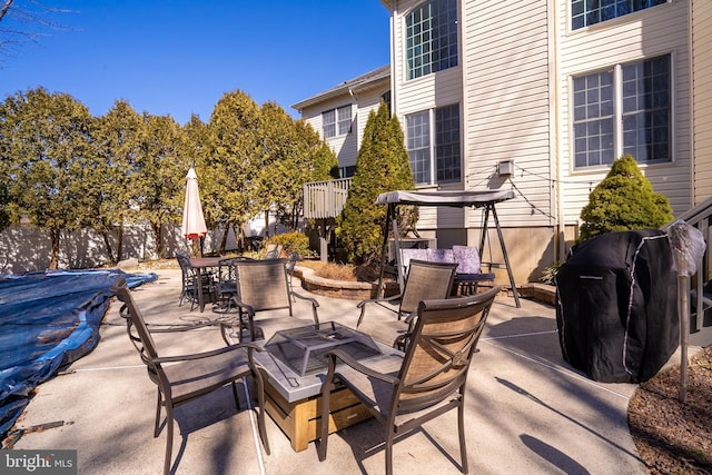 view of patio featuring a fire pit, outdoor dining space, grilling area, and a fenced in pool