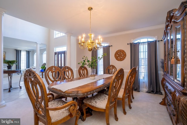 dining space with light tile patterned floors, a notable chandelier, light carpet, decorative columns, and crown molding