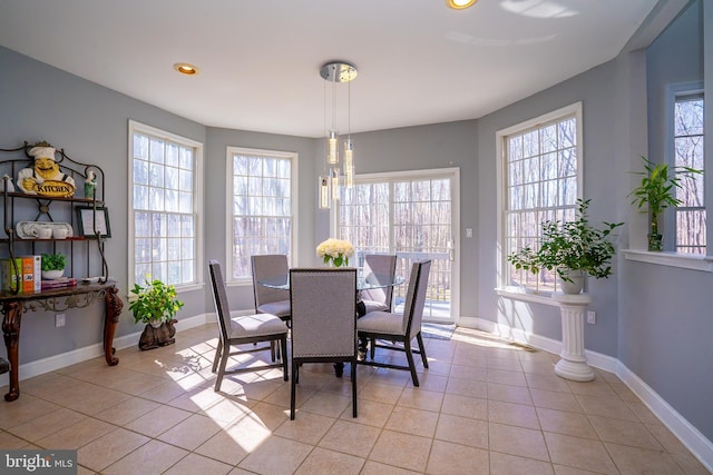 dining space featuring plenty of natural light, light tile patterned flooring, and baseboards