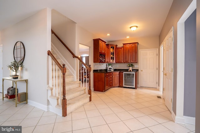 kitchen with baseboards, wine cooler, glass insert cabinets, light tile patterned flooring, and recessed lighting