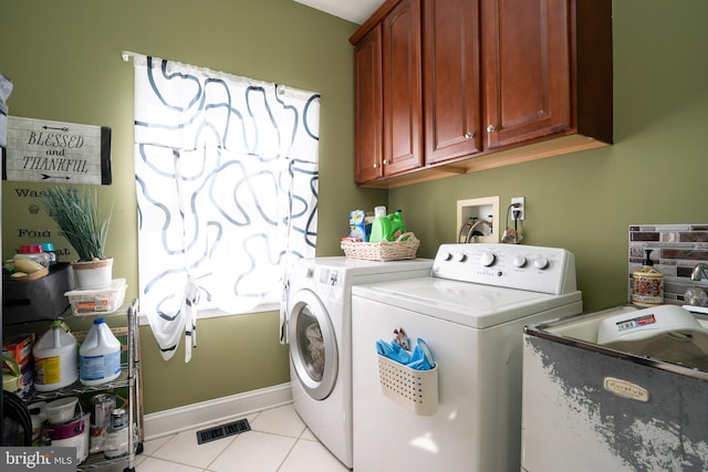 clothes washing area featuring cabinet space, baseboards, independent washer and dryer, a sink, and light tile patterned flooring