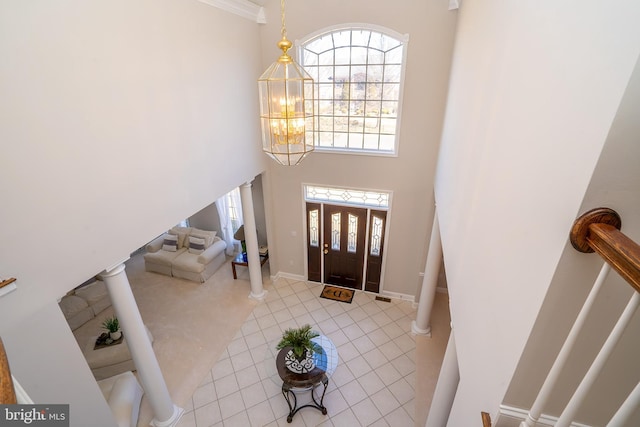 foyer featuring baseboards, a high ceiling, an inviting chandelier, and tile patterned floors