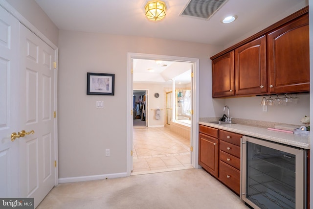 bar with light tile patterned floors, wine cooler, a sink, visible vents, and baseboards