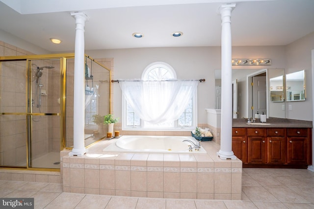 bathroom featuring decorative columns, a stall shower, vanity, a bath, and tile patterned floors