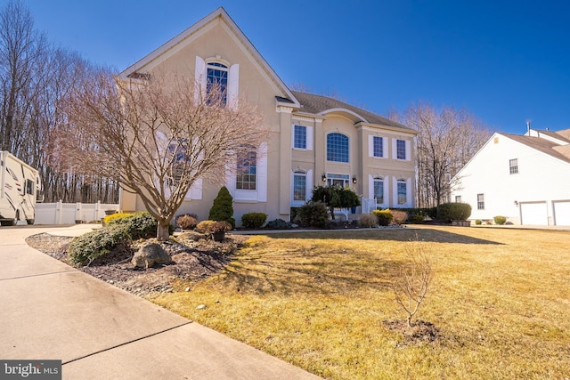 view of front facade featuring fence, a front lawn, and stucco siding