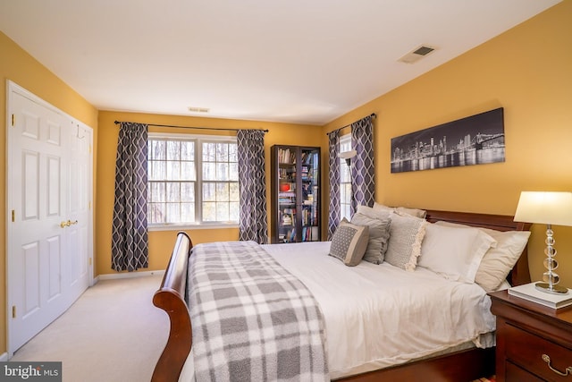 carpeted bedroom featuring visible vents and baseboards