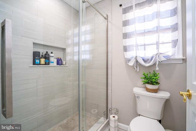 bathroom featuring toilet and a stall shower