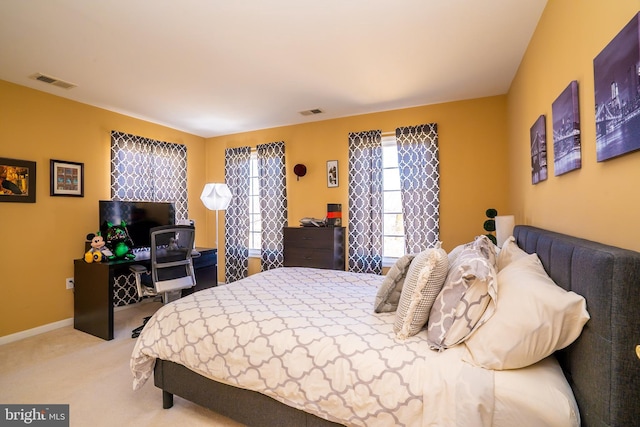 bedroom with light carpet, visible vents, and baseboards