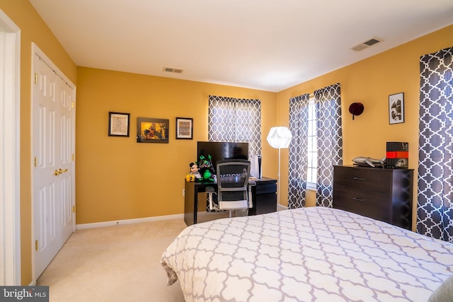 bedroom featuring baseboards, visible vents, and light colored carpet