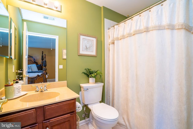 bathroom featuring toilet, vanity, and visible vents