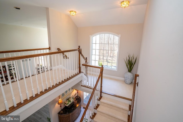 stairs featuring baseboards and vaulted ceiling