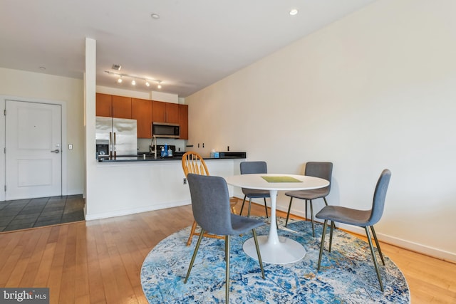 dining area featuring light wood finished floors, recessed lighting, and baseboards