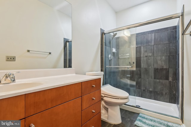 bathroom with toilet, a shower stall, and vanity