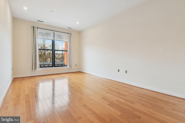 unfurnished room with recessed lighting, baseboards, visible vents, and light wood finished floors