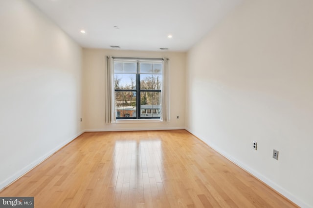 spare room with light wood finished floors, visible vents, baseboards, and recessed lighting