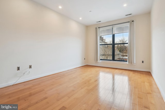 unfurnished room featuring light wood finished floors, recessed lighting, visible vents, and baseboards