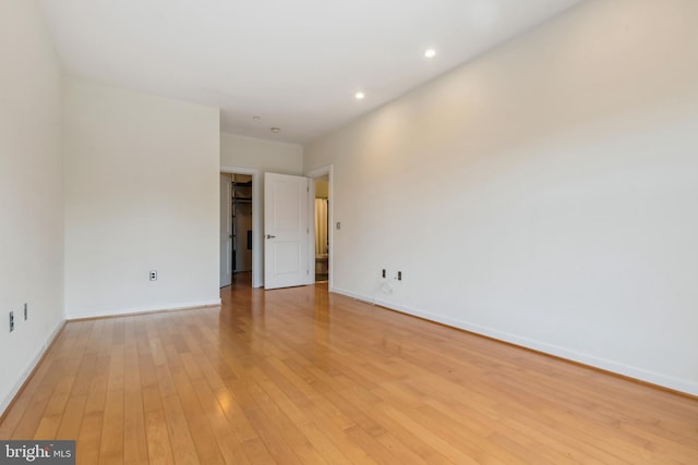 unfurnished room featuring light wood finished floors, baseboards, and recessed lighting