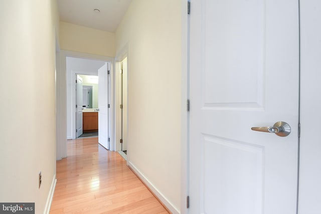 hall featuring baseboards and light wood finished floors