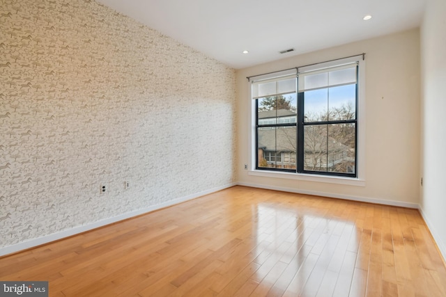 spare room with recessed lighting, light wood-type flooring, visible vents, and baseboards