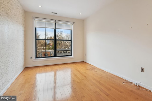 spare room with baseboards, recessed lighting, visible vents, and light wood-style floors