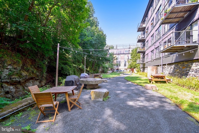 view of property's community featuring a fire pit and a patio