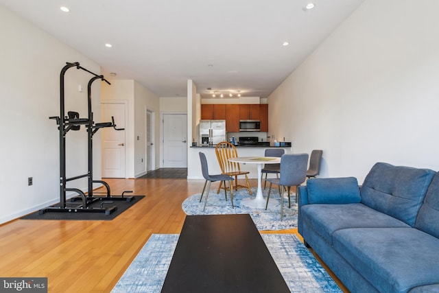 living room featuring recessed lighting, baseboards, and wood finished floors